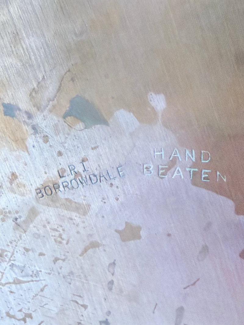 Lakeland Borrowdale hammered copper tray with warm patina, photographed on a white surface beside dried stems.