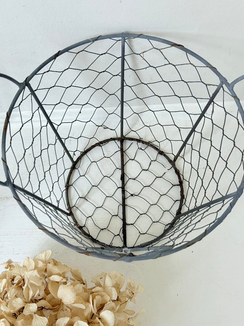 Pair of vintage decorative wire baskets with heart detail and aged patina photographed on a white surface