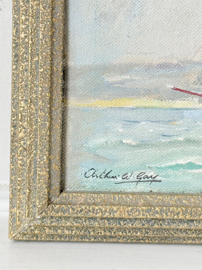 Close-up of a framed painting showing the corner of a seascape with textured gold frame, painted waves, and an artist signature reading Richard W. Gay.