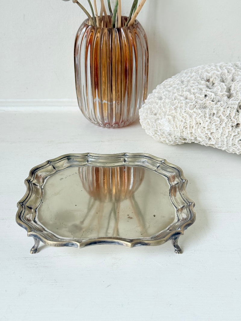 Vintage silver plate tray with scalloped edge and footed base, photographed on a white surface