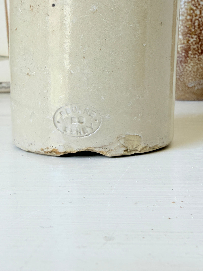 Three antique stoneware bottles, a printed Caley of Norwich and a Portuguese Campos Filhos, photographed on a white surface