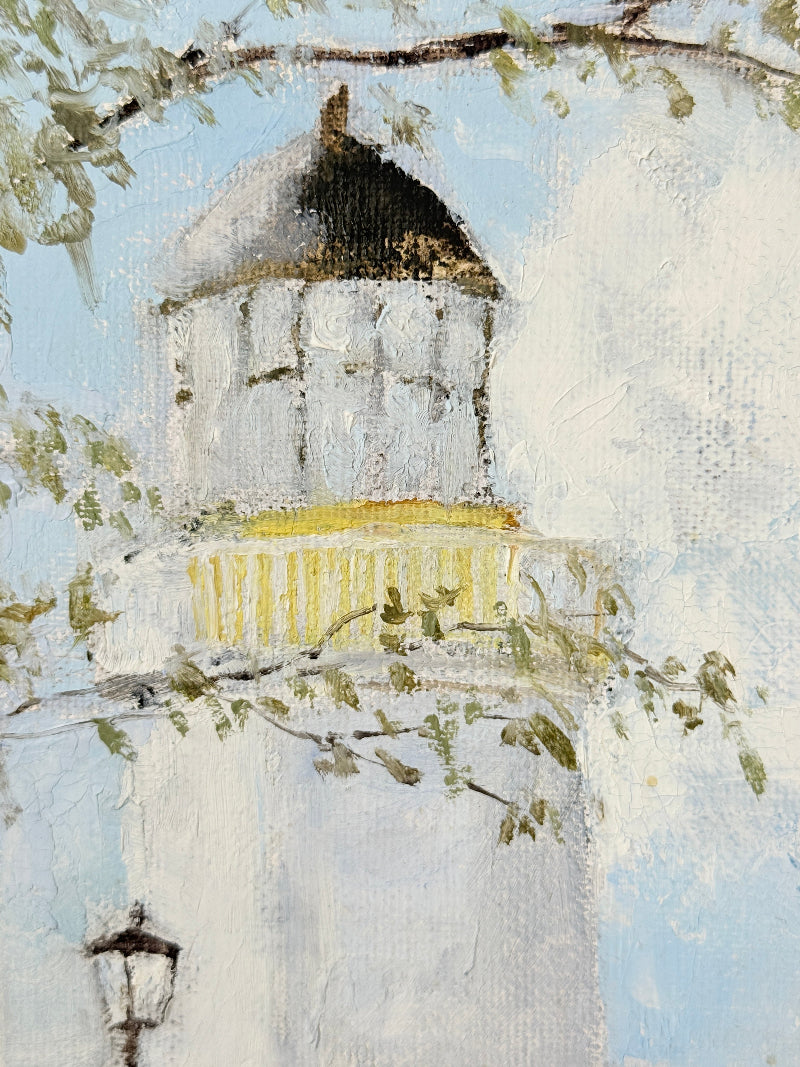 An impressionistic painting of a white building with a dark conical roof, a yellow band around the middle, and leafy branches in the foreground against a pale blue sky.