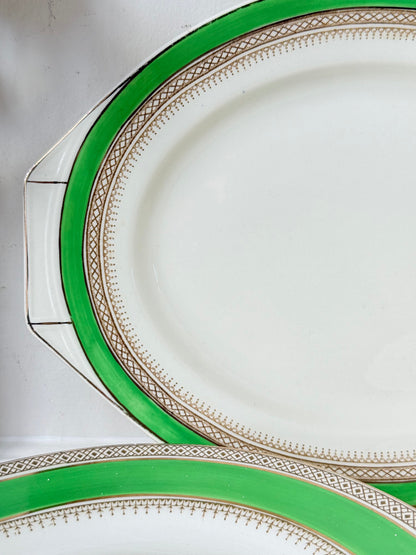 Pair of vintage oval serving platters with bright green Art Deco style border photographed on a white surface