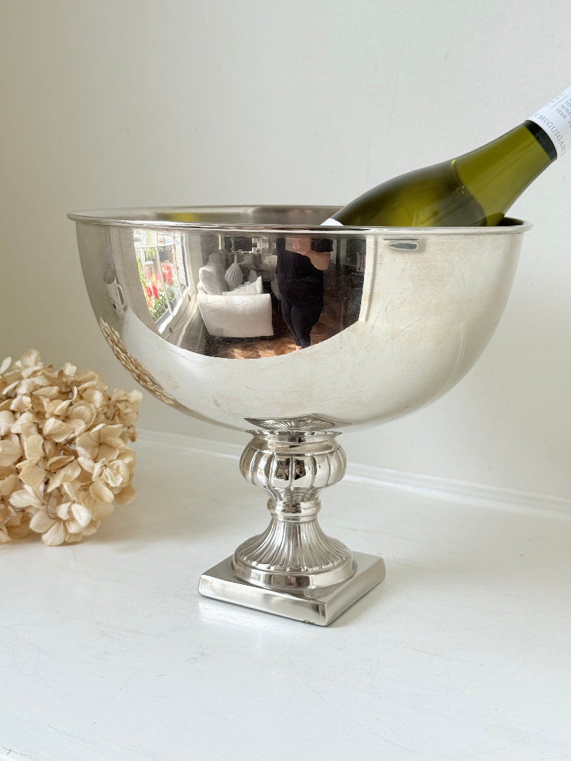Vintage polished metal champagne bowl with pedestal base, photographed on a white surface