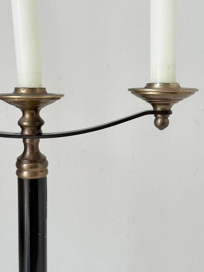 Vintage three arm candelabra in brass and ebonised metal with ivory taper candles styled on a white surface