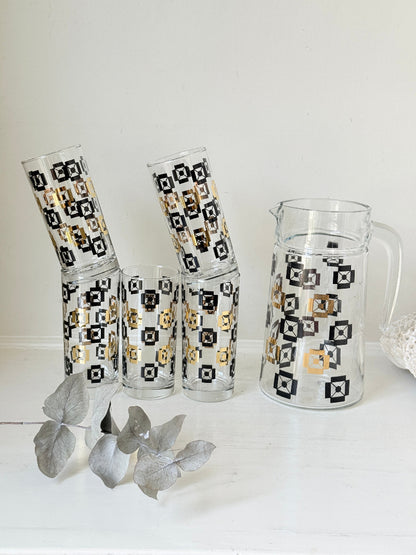 Mid century black and gold glass drinks set with jug and five highball tumblers in a geometric medallion pattern