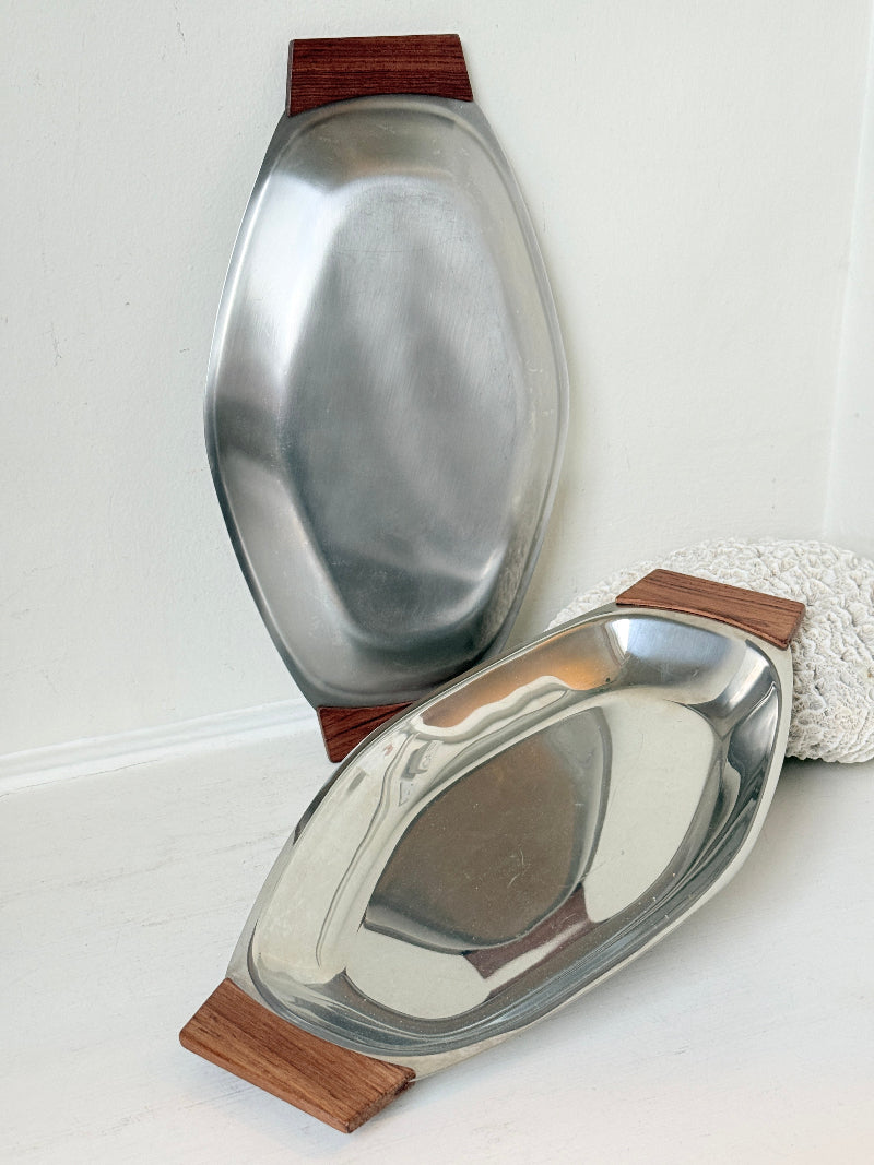 Pair of mid century stainless steel and teak crudites dishes photographed on a white surface