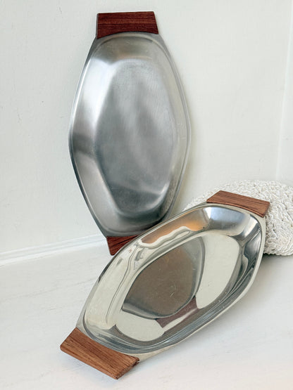 Pair of mid century stainless steel and teak crudites dishes photographed on a white surface