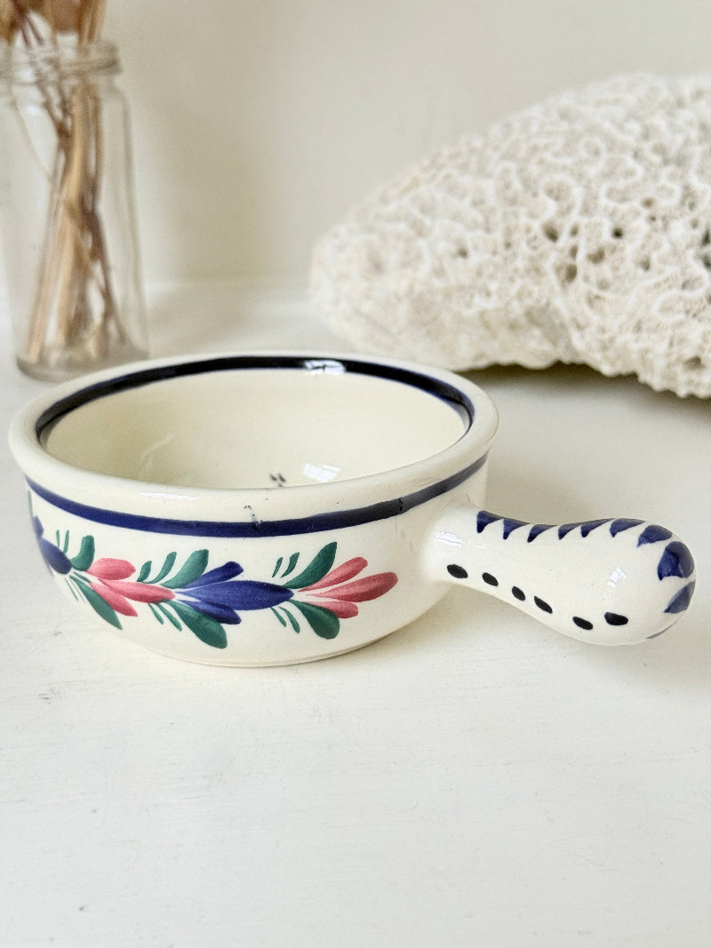 French Quimper faience handled olive bowl with Petit Breton figure and blue rim, photographed on a white surface