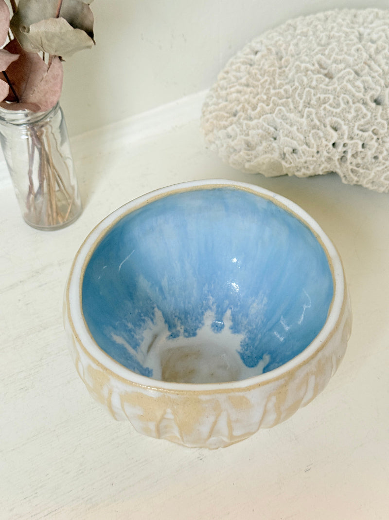 Vintage studio pottery bowl planter in cream and sky blue glaze photographed on a white surface