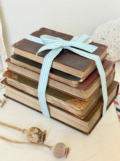 Vintage decorative brown book bundle with aged hardback covers tied with blue stripe ribbon for bookshelf and table styling