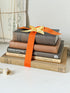 Vintage decorative book bundle in orange and brown with aged hardback covers and bright orange ribbon for shelf styling