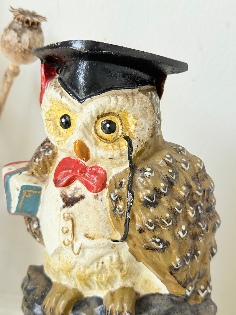 vintage hand painted cast iron owl doorstop with mortarboard and bow tie on white surface
