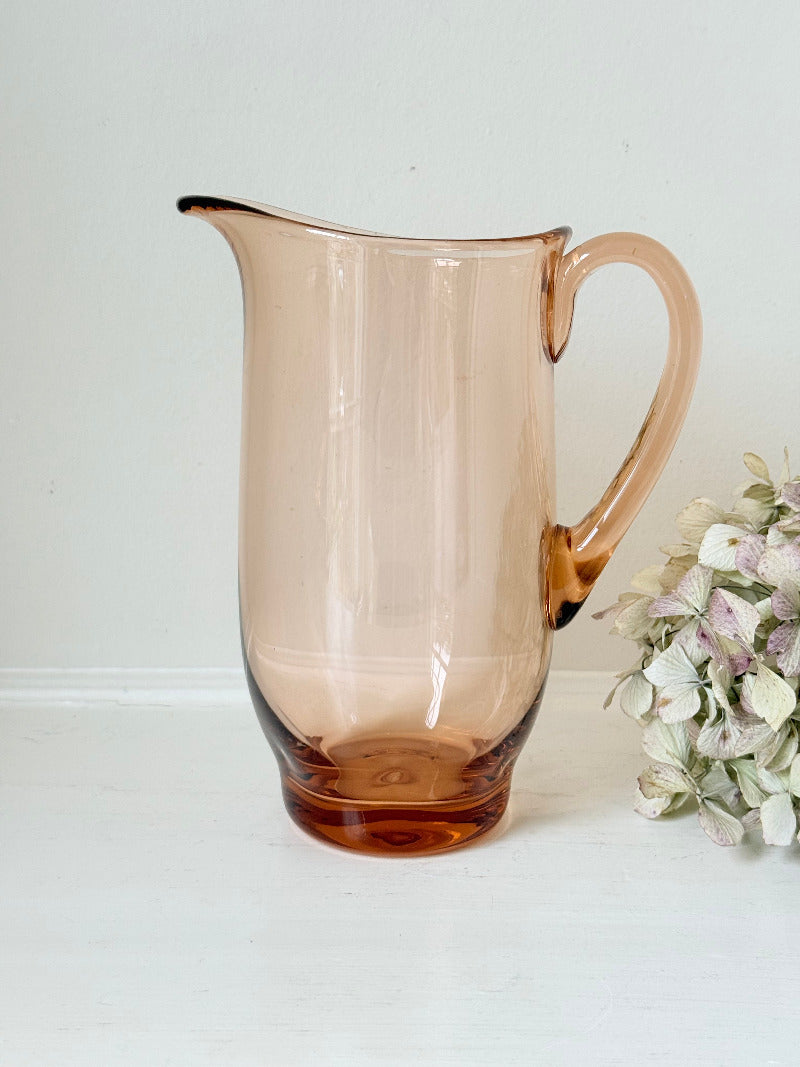 retro apricot glass serving jug with curved handle and flared spout, photographed on white surface