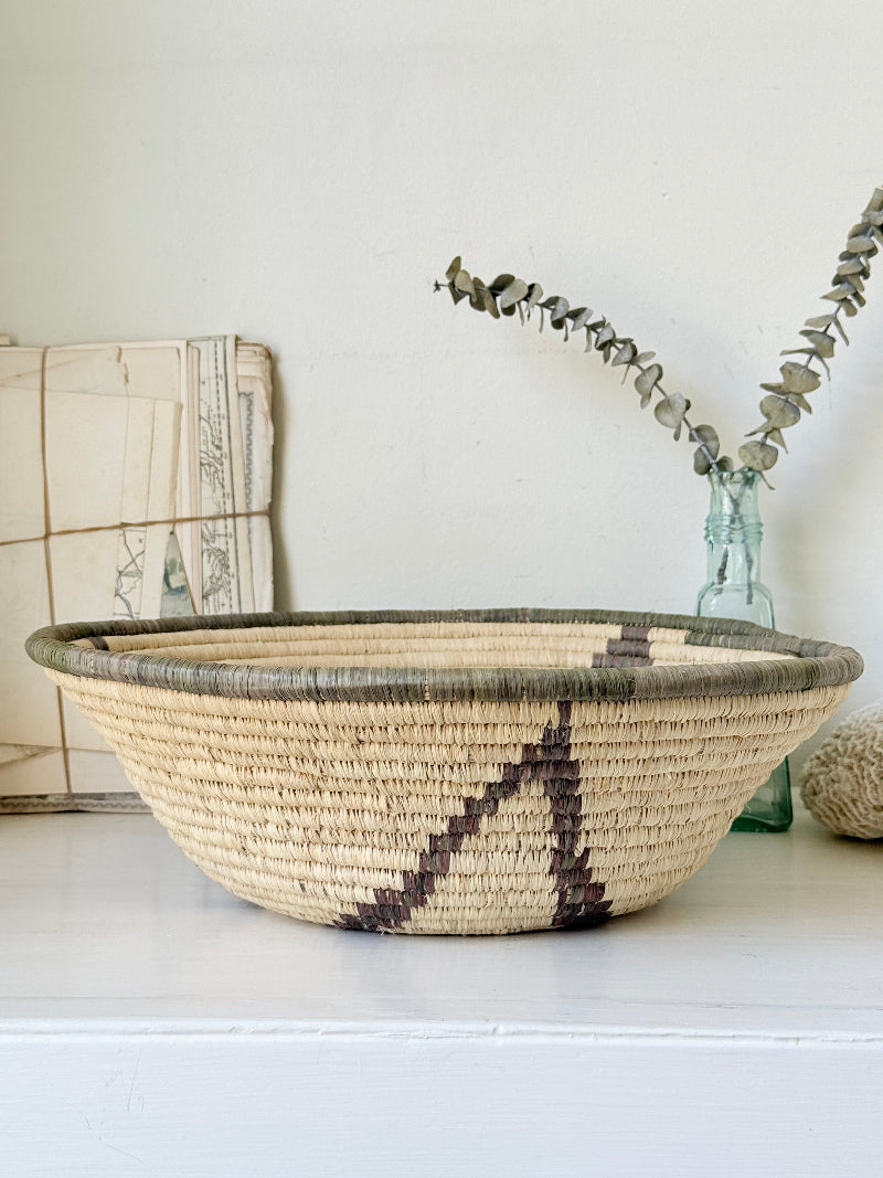 Large hand woven coiled basket with three point star pattern, natural fibre and dark geometric detail for wall or table styling