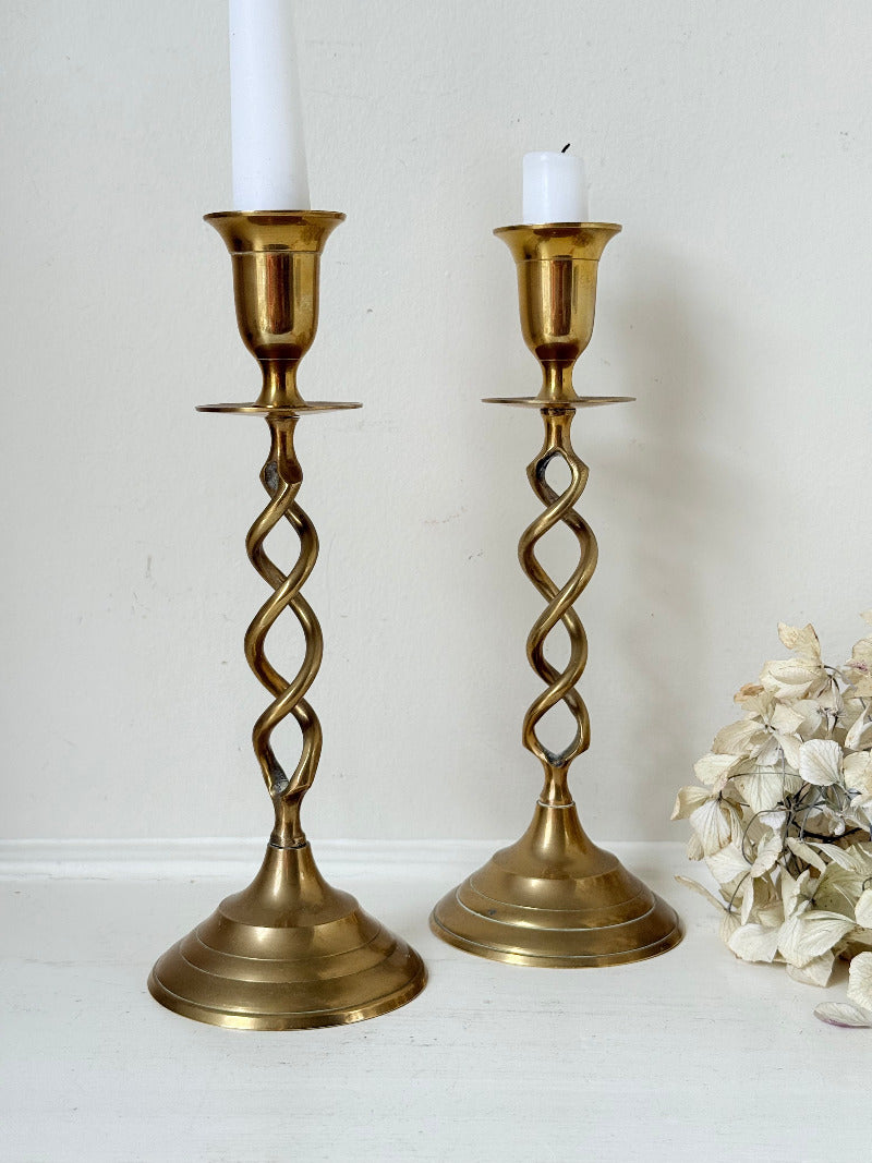 pair of brass candlesticks with spiral twist stems photographed on white surface
