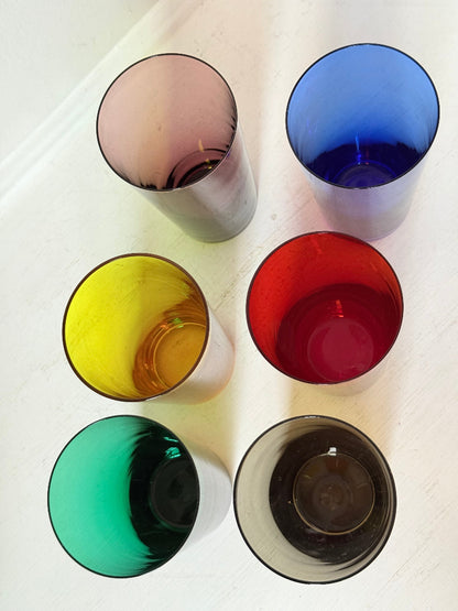 Set of six mid-20th century Boussu coloured glass tumblers in green, yellow, red, violet, blue and brown, photographed on white surface.
