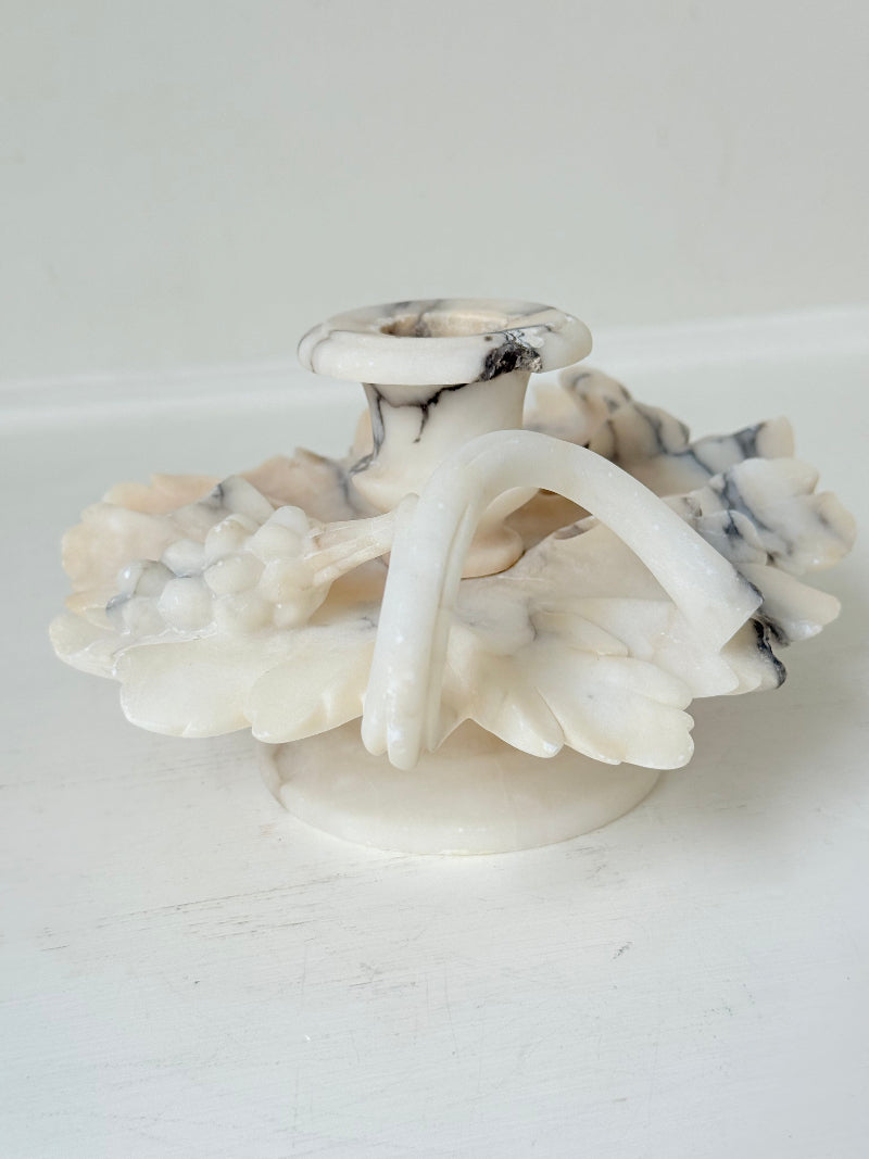 Antique alabaster marble floral candleholder with carved leaves and flowers, photographed on a white surface.