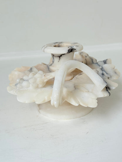 Antique alabaster marble floral candleholder with carved leaves and flowers, photographed on a white surface.