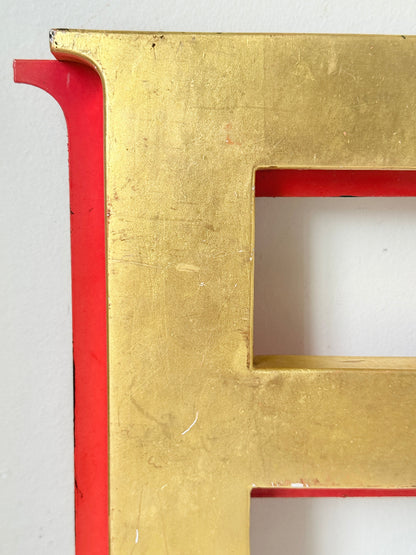 A close-up of a large gold letter &