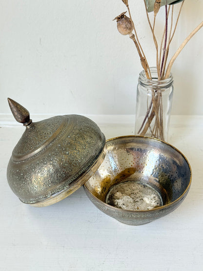 Indian Benares brass lidded jar with floral engraving and finial, photographed on a white surface
