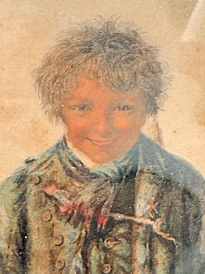 Vintage print of Little Beggar Boy in muted colours, framed under glass in simple wooden frame, on white surface.