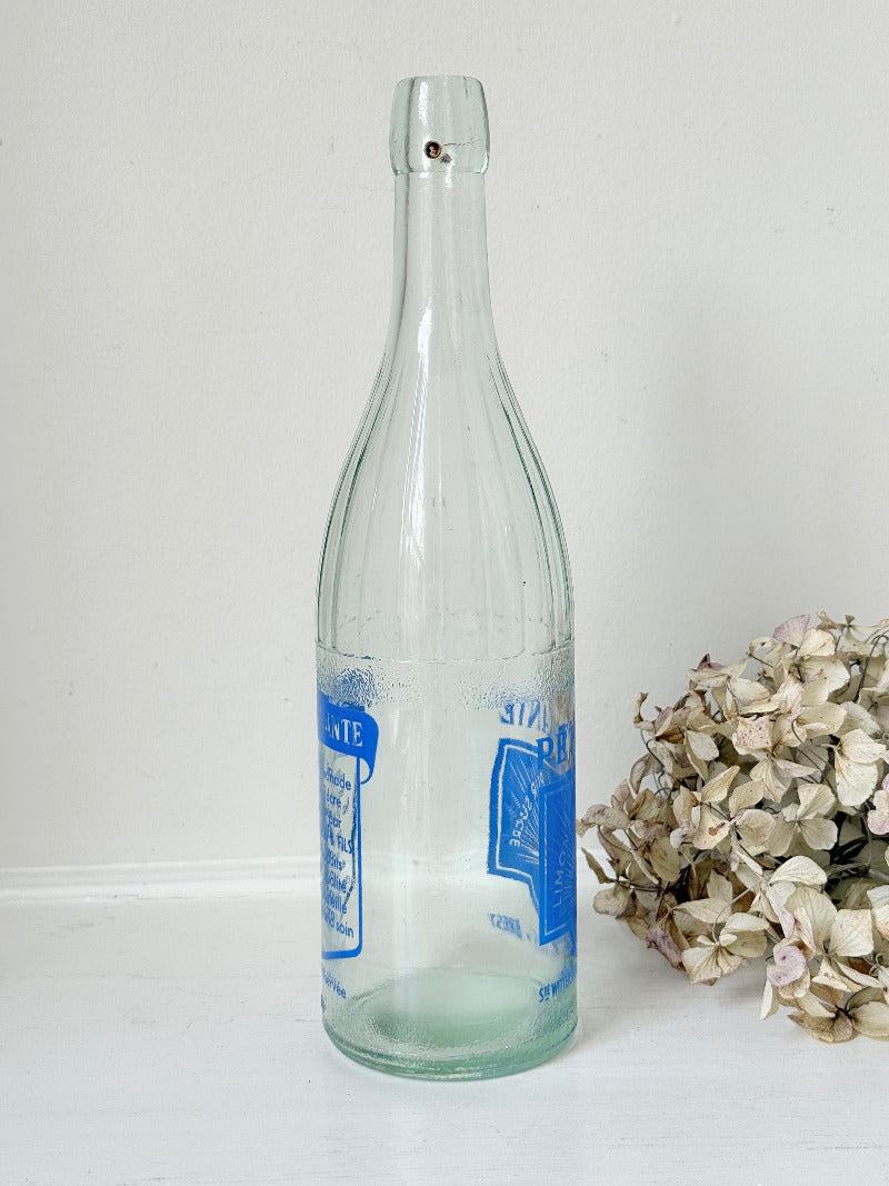 vintage french lemonade bottle la pétillante blue label on white surface with hydrangea flowers