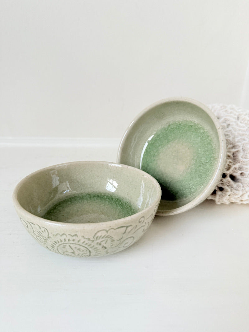 Pair of sage green Thai celadon olive bowls with crackled glaze, photographed on white surface