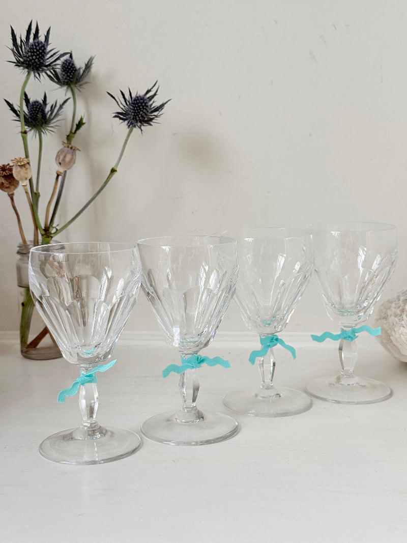 Set of four vintage cut crystal aperitif glasses with faceted bowls, photographed on a white surface