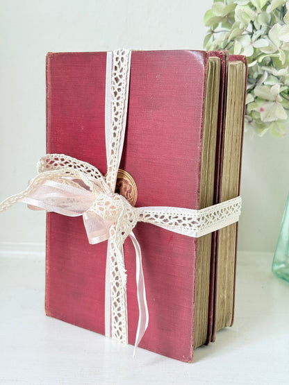 Pair of vintage Rudyard Kipling books in red cloth bindings with gilt lettering, styled as a decorative bundle, photographed on a white surface