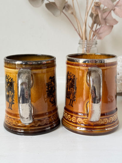 Pair of Ridgways stoneware tankard mugs photographed on a white surface in amber brown glaze with black Coaching Days and Coaching Ways transfer scenes