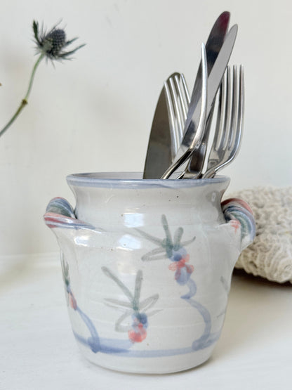 Vintage studio pottery utensil pot with hand painted floral decoration and applied handle detail, photographed on a white surface