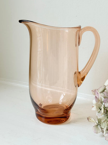 retro apricot glass serving jug with curved handle and flared spout, photographed on white surface