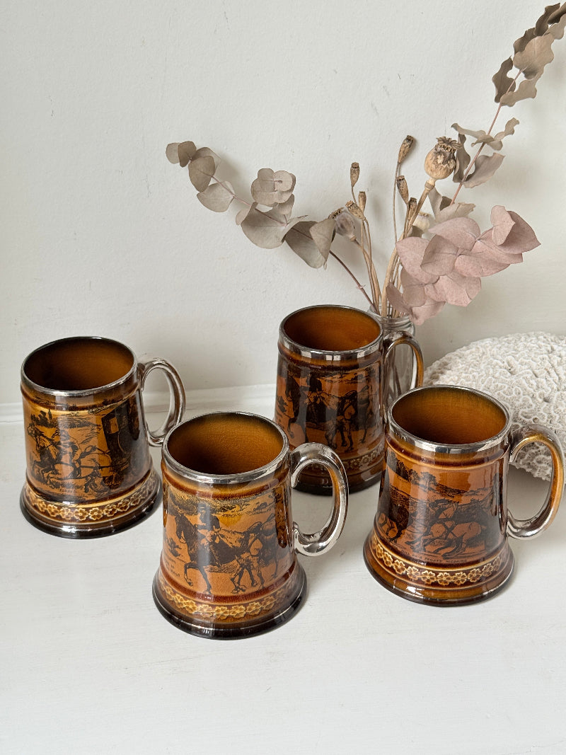 Set of 4 antique Ridgway stoneware beer tankards photographed on a white surface in amber treacle glaze with black Coaching Days and Coaching Ways scenes