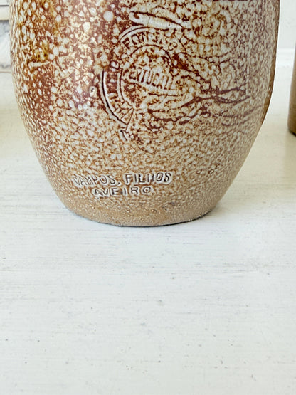 Three antique stoneware bottles, a printed Caley of Norwich and a Portuguese Campos Filhos, photographed on a white surface