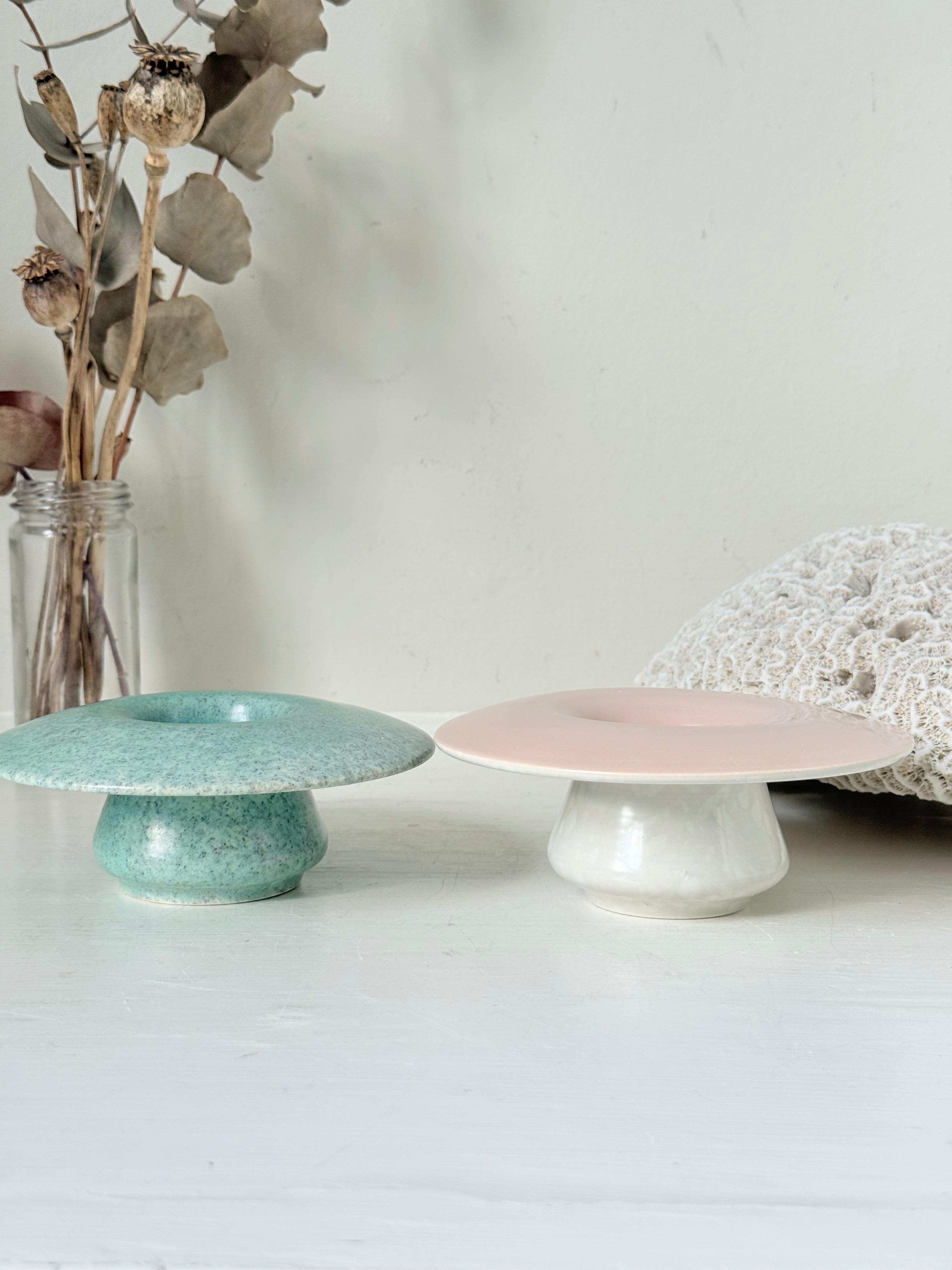 Pair of Poole Pottery mushroom posy vases in seafoam green and blush pink glazes photographed on a white surface