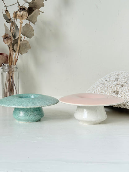 Pair of Poole Pottery mushroom posy vases in seafoam green and blush pink glazes photographed on a white surface