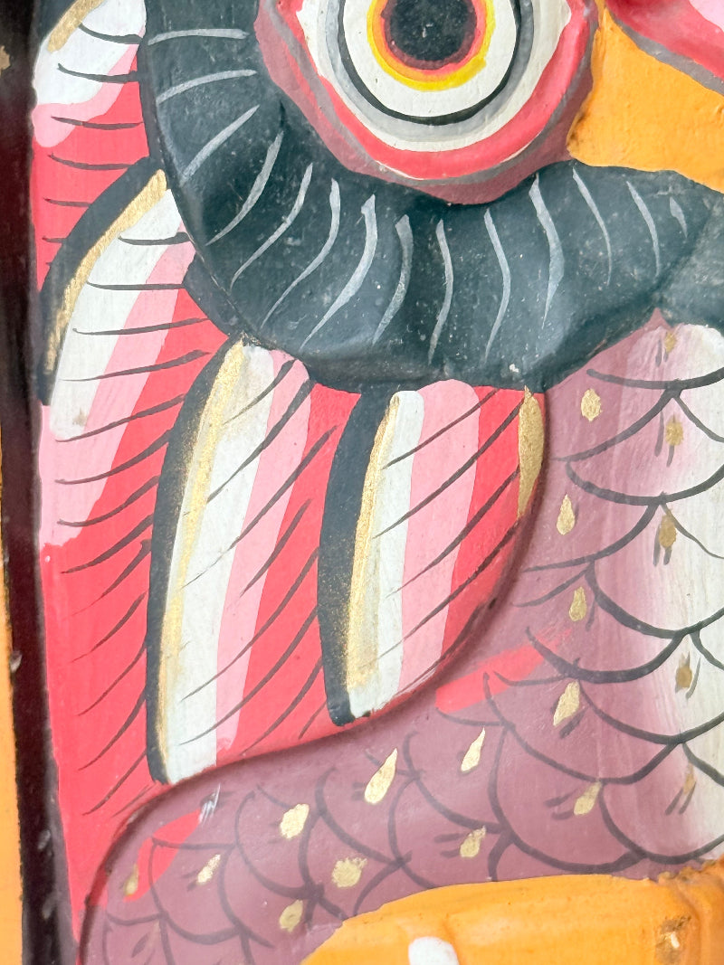 Vintage wooden owl bookends hand painted in red and orange tones, displayed on a white surface beside dried flowers.