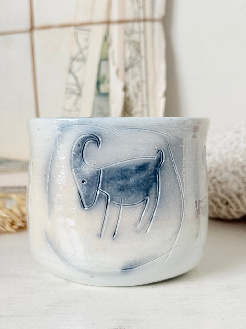 Hand painted ceramic pot with blue ram motif, pale grey off white glaze and handmade decorative form