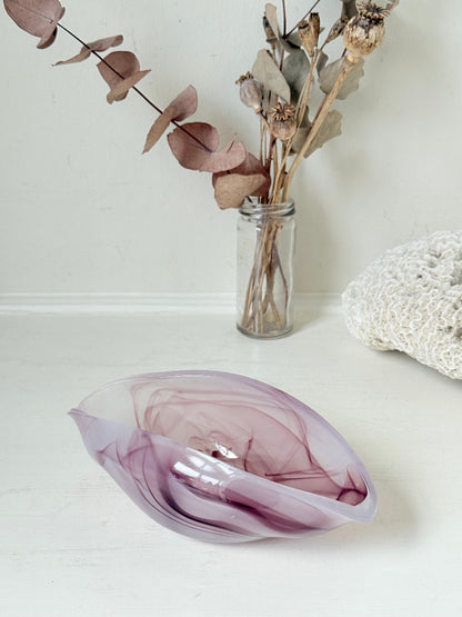 Vintage clam shaped Sowerby glass bowl in lilac purple swirl photographed on a white surface