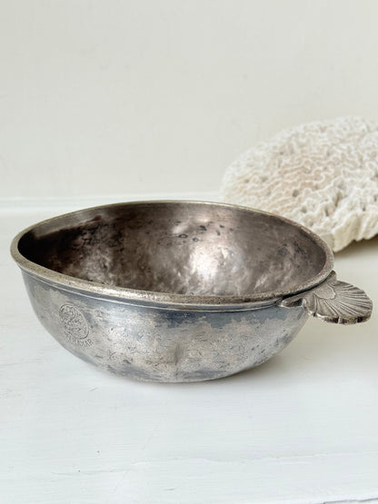 Antique Christofle silver plate bowl with decorative handle, photographed on a white surface.