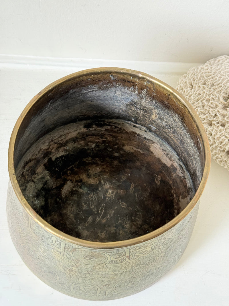 Large vintage brass pot with engraved decoration and aged patina, photographed on a white surface