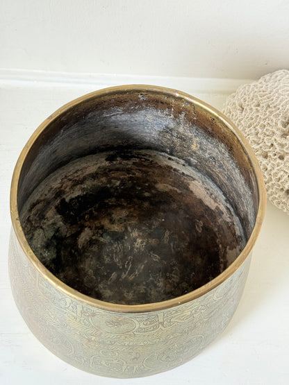 Large vintage brass pot with engraved decoration and aged patina, photographed on a white surface
