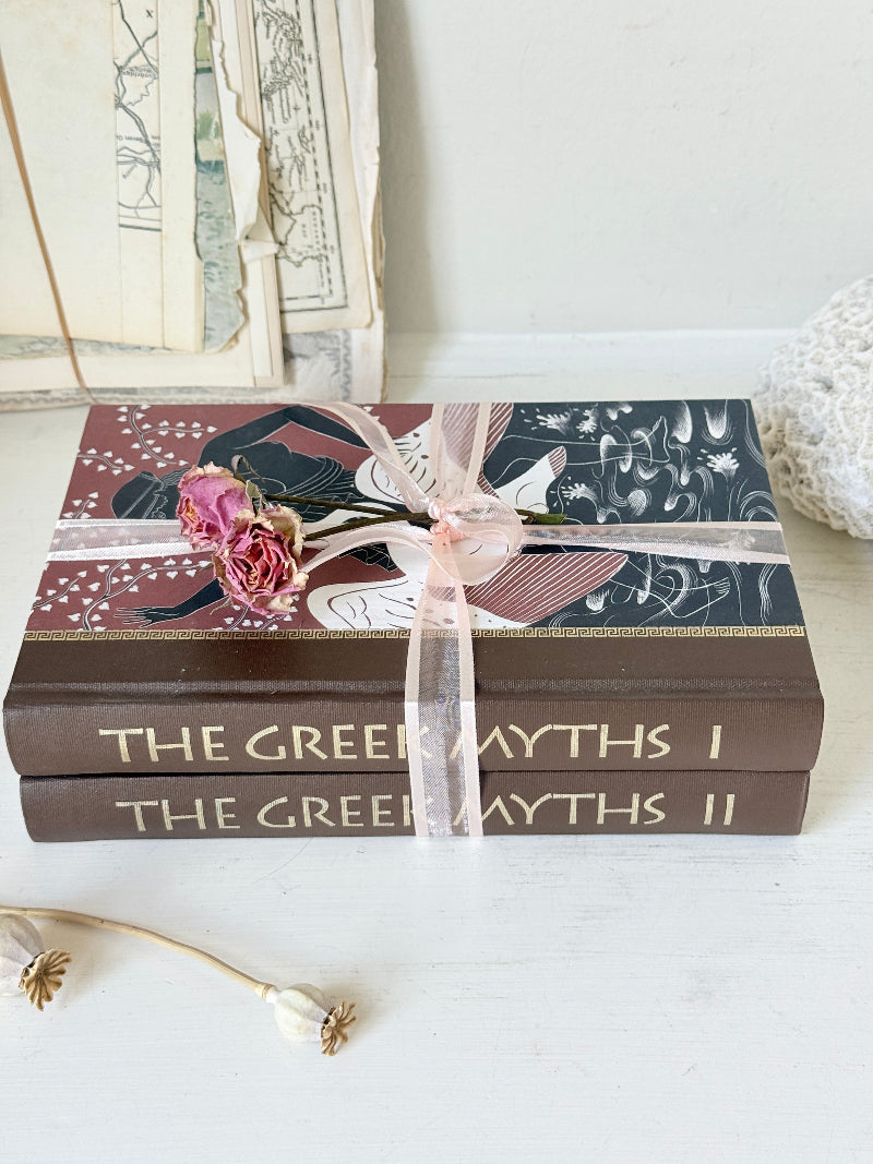 Pair of vintage Greek myths books with brown illustrated covers, pale pink ribbon and dried flower detail for shelf styling