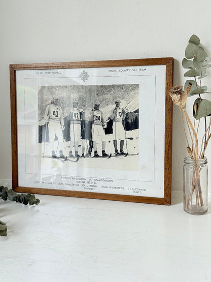 Vintage black and white framed photograph of the 1st Battalion Irish Guards Ski Team, 1963–64, posed in full ski gear against the Austrian Alps.