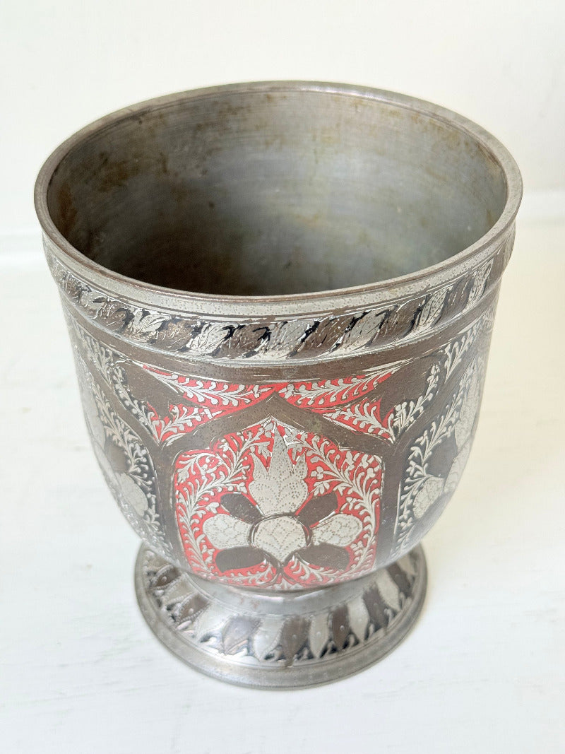 vintage indian metal lassi cup with red and white enamel motifs, styled with dried hydrangeas on a white surface