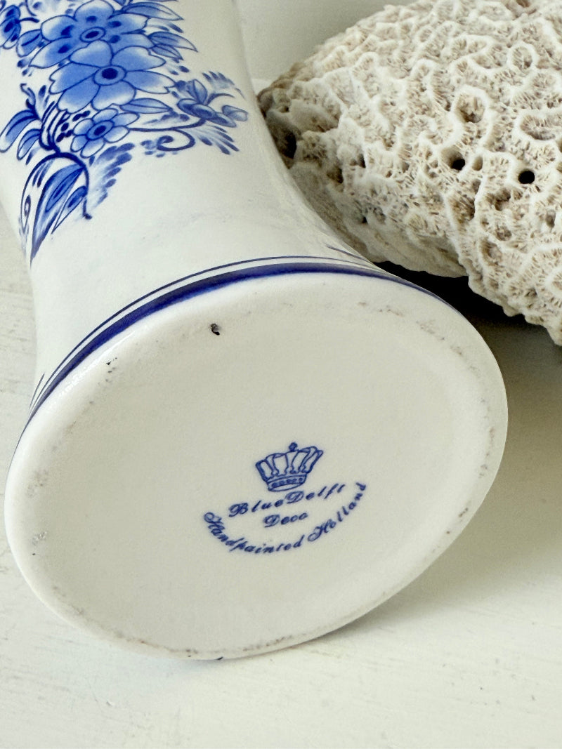 Blue and white Delft hand painted ceramic vase with windmill and floral decoration, photographed on white surface.