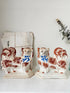 Pair of antique standing Staffordshire Pekingese dogs in rust red and white with blue painted bows