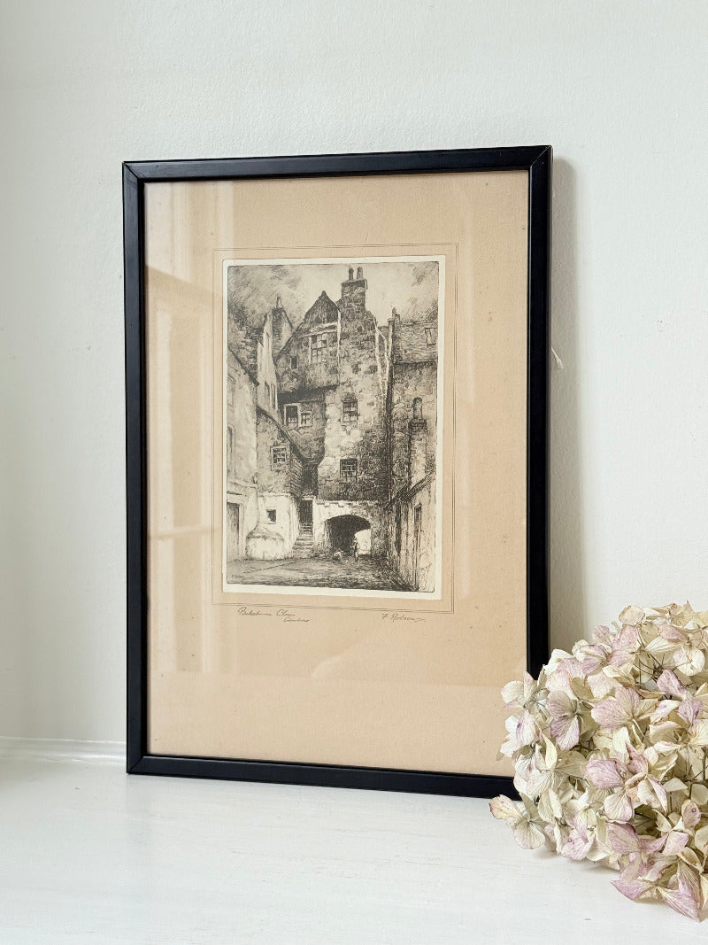 framed black and white print of edinburgh old town architecture photographed on white surface