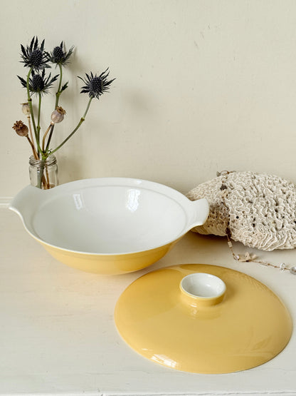 Vintage Poole Pottery lidded serving dish in soft yellow glaze with side handles, photographed on a white surface